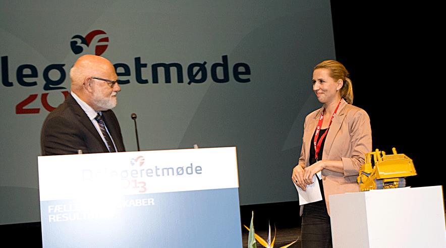 Poul Erik Skov Christensen forærede Mette Frederiksen en bulldozer for at minde hende om, at 3F længe har ønsket at køre en bulldozer gennem beskæftigelsessystemet. 
- Tag den med hjem til din søn Magne, så den kan minde dig om det, også når du har fri, sagde formanden for 3F's a-kasse.  (Foto: Harry Nielsen)