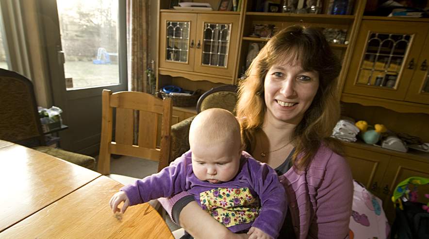 39-årige Berta Hansen blev ulovligt fyret, da hun blev gravid kort efter endt barsel. Her sidder hun med datteren Tammie på tre måneder. (Foto: Harry Nielsen)