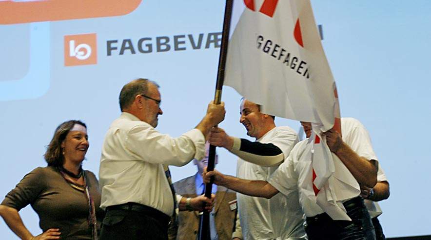 Sebastian Stolarczyk fra den polske klub under de københavnske byggefag overrækker LO-formand Hans Jensen en fane ved LO-kongressen.  (Foto: Harry Nielsen.)