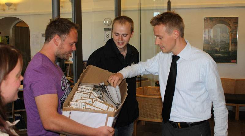 Tim Callesen, ungdomskonsulent i  TIB, og Søren Grøn, formand i 3F Ungdom, afleverer 2.949 underskrevne postkort til finansministerens pressechef. (Foto: Mikkel Secher)