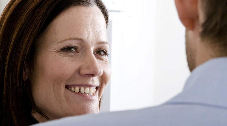 Smil og øjenkontakt gør det nemmere at starte en uformel samtale med dine kolleger. (Foto: Colourbox)