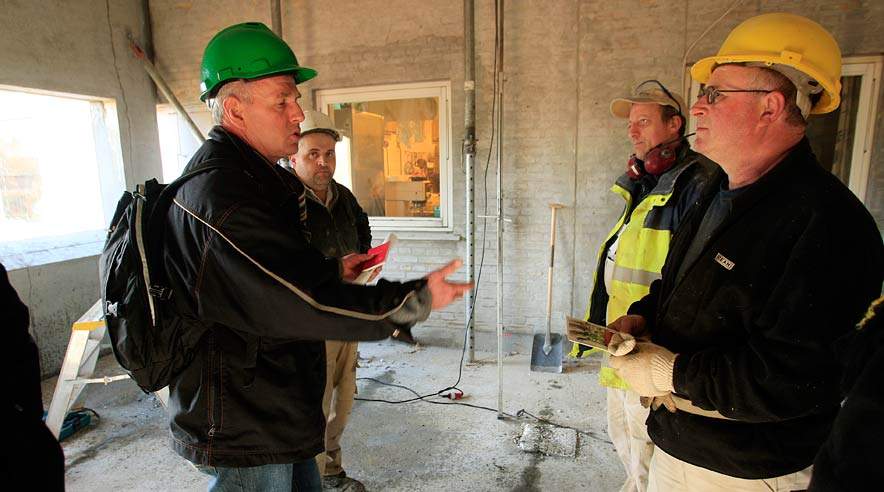 Faglig sekretær Michael Liesk (med grøn hjelm) fra 3F Frederiksborg forklarede tre tyske betonarbejdere, at det forventes, at de bliver medlem af 3F.  (Foto: Harry Nielsen.)