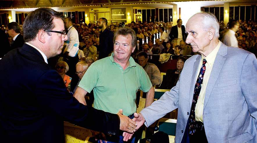 74-årige Per Svensson (th) hilser på Danisco's direktør, Tom Knutzen (tv) inden generalforsamlingen.  Han blev allerede som 31-årig svært hjerneskadet efter bare få års arbejde på Grindstedværket. Han var inviteret af formanden for Kritiske Aktionærer, Frank Aaen (midten), til at komme og tale kviksølvofrenes sag foran de mange aktionærer og Daniscos bestyrelse og direktion.  (Foto: Thorkild Amdi.)