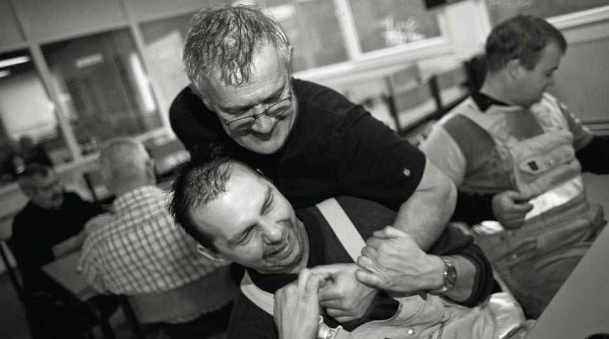 Svend Aage Haandbæk (stående) og Henrik Schneider Jensen (siddende) arbejder sammen på havnen i Esbjerg. Der er ofte meget ventetid, mellem at skibene skal lodses, hvor der bliver spillet kort og talt om livets gang. (Foto: Kent Klich)