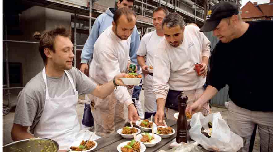 Nikolaj Kirk serverer (for lidt) Crispy kylling for de skrupsultne murere fra Øernes Byggefirma. (Søren Zeuth)