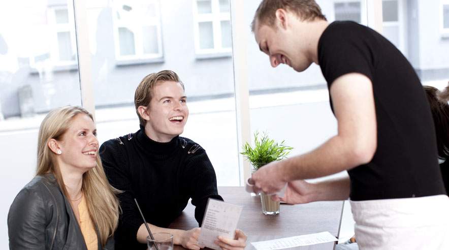 Husk at medbringe smilet og det gode humør på arbejdet, hvis du vil sikre dig flere drikkepenge. (Foto: Colourbox)
