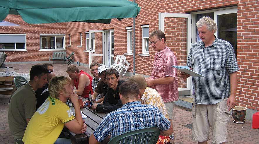 De ti lettiske bygningsarbejdere samlet i gårdhaven hos 3F Frederiksborg i Hillerød til møde med de faglige sekretærer Michael Drachmann (th) og Jesper Nielsen.