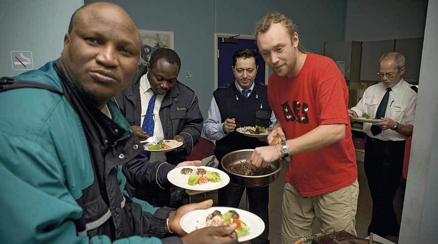 Dejlig mad gør det lettere at smile til passagererne, mener Abdoy Ceesay (forrest), der nyder Nikolaj Kirks (til højre) kebab.