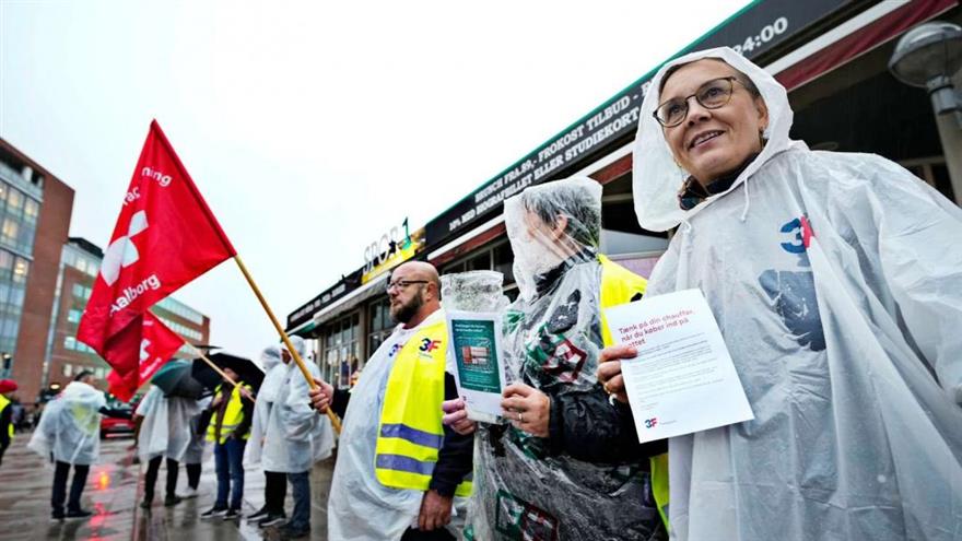 Røde faner, smil og regnvejr på Aalborg Busterminal, hvor der tirsdag morgen var demonstration. (
Foto: Niels Aage Skovbo)